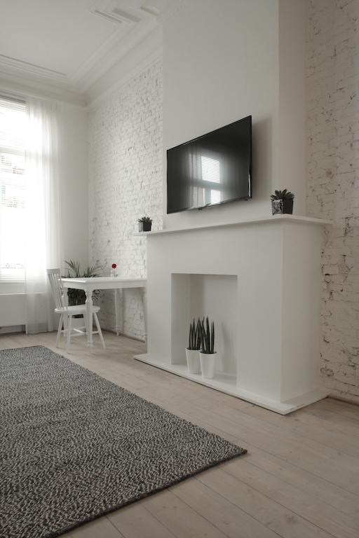 Maison Nationale City Flats & Suites Αμβέρσα Δωμάτιο φωτογραφία A fireplace with a TV above it