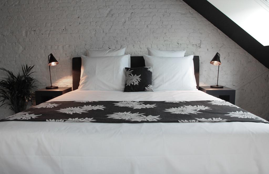 Maison Nationale City Flats & Suites Αμβέρσα Δωμάτιο φωτογραφία A bed with a bed runner
